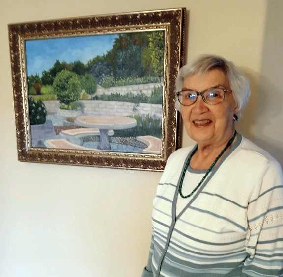 Arlene is standing next to the painting that Don started and she finished.